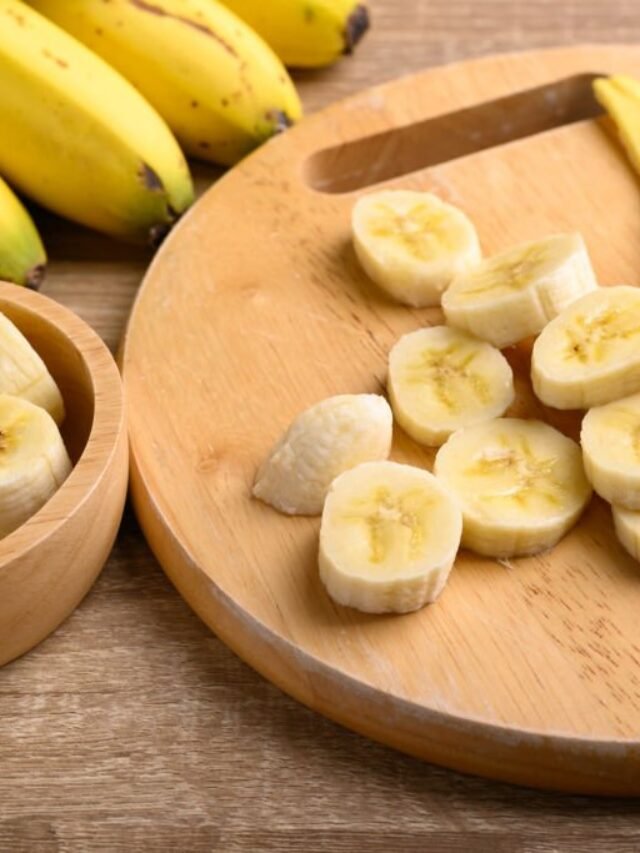 Sliced ripe banana fruit on wooden cutting board preparing for cooking