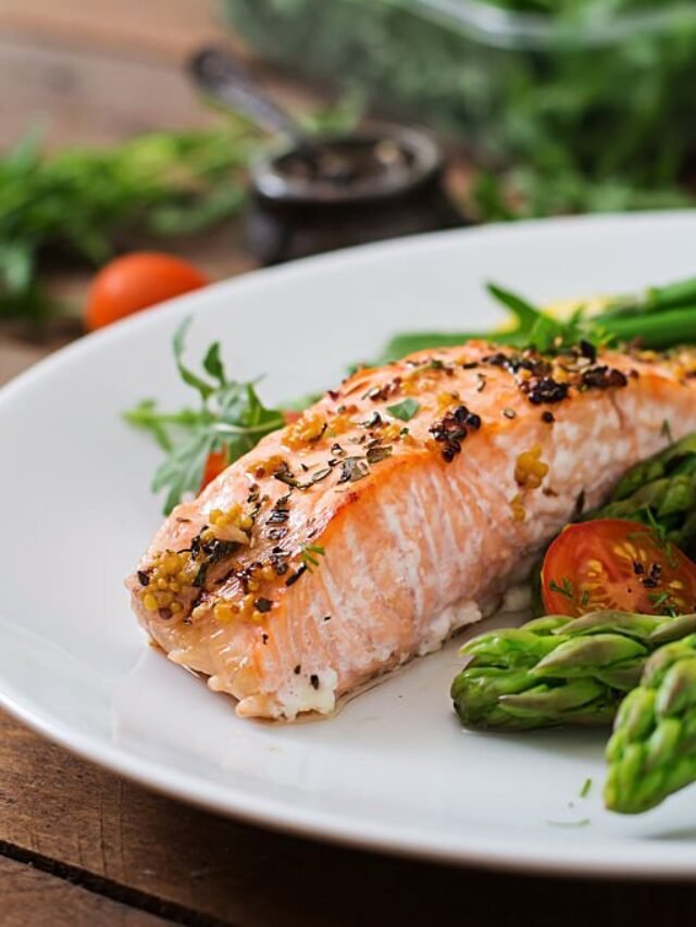 Baked salmon garnished with asparagus and tomatoes with herbs