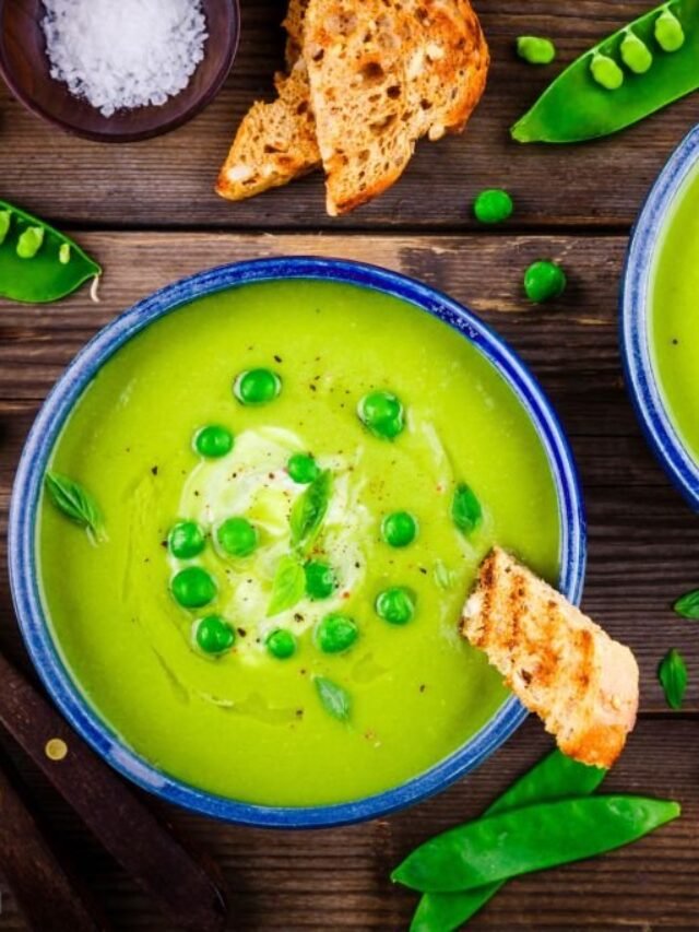 Green pea soup with croutons on wooden rustic background